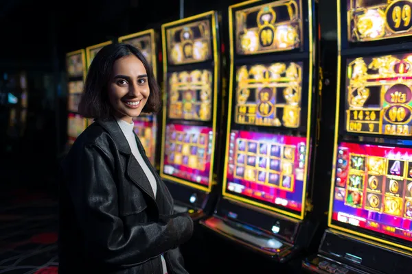 A woman smiling while playing online games on her laptop, surrounded by neon casino elements, showcasing 786BETT’s diverse game collection.
